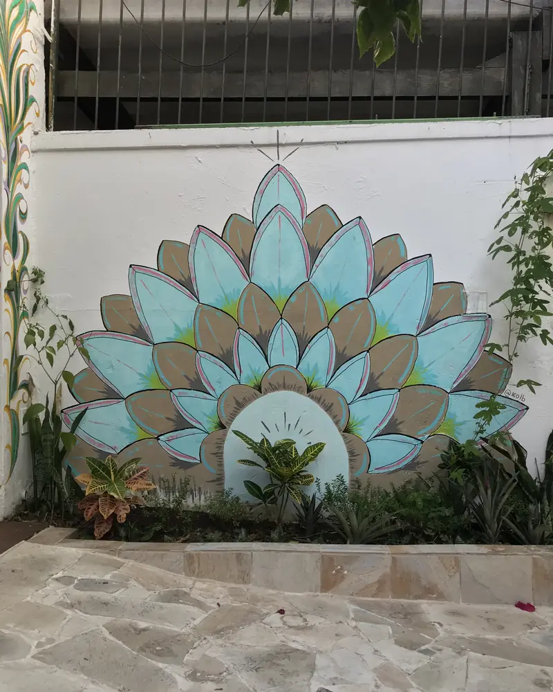 Blue lotus mural on a white garden wall