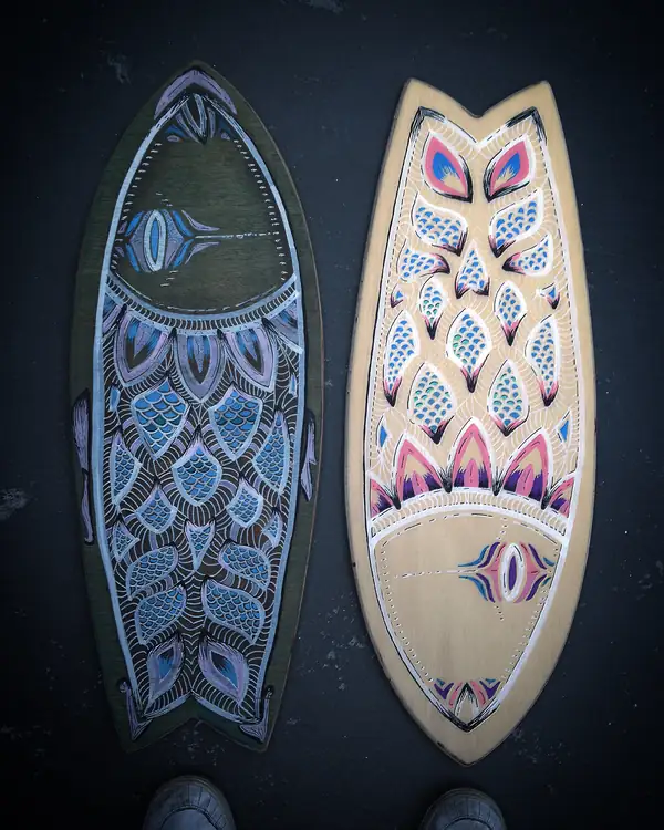 Two painted fish-shaped boards